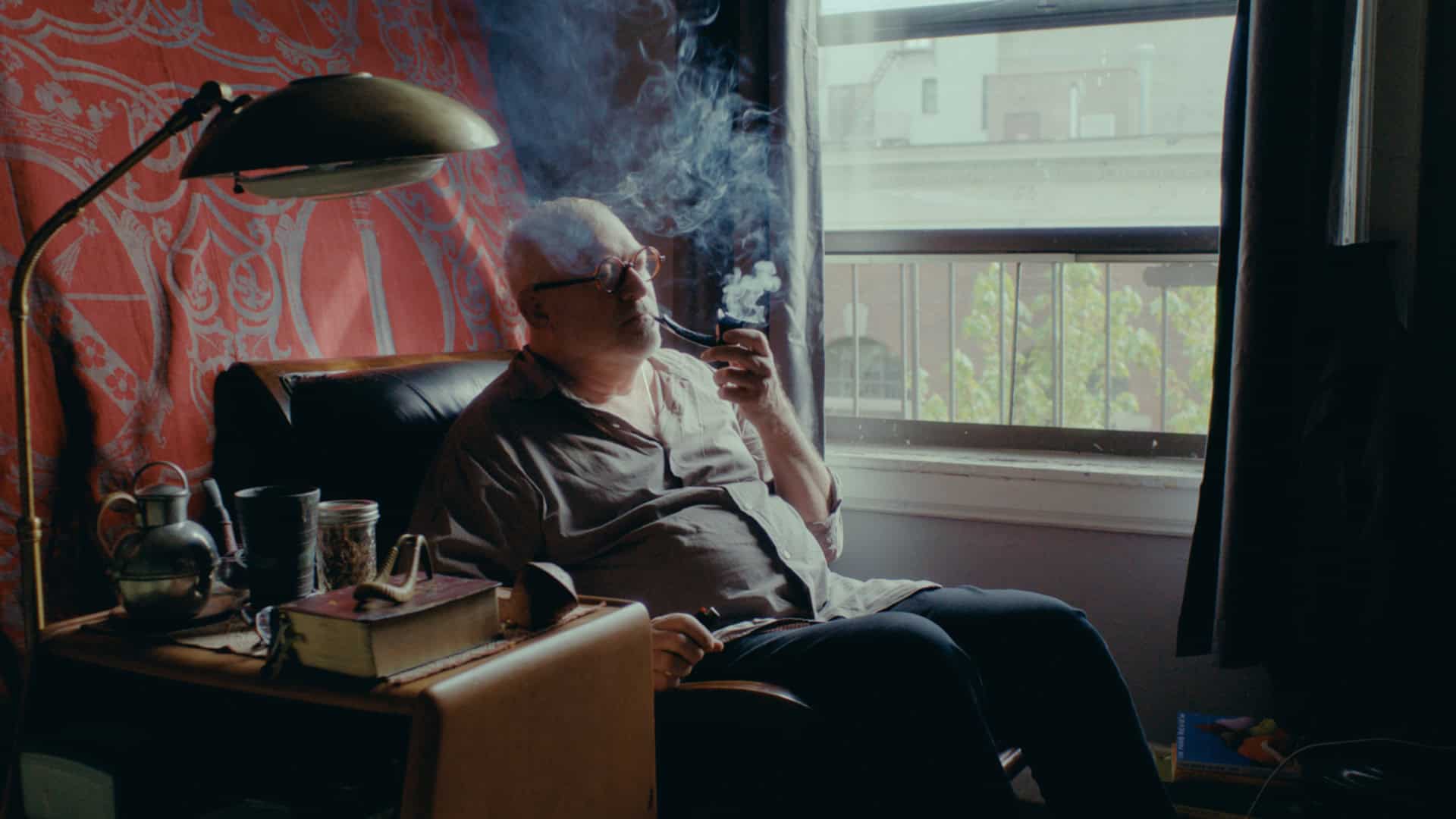 Alfonse Borysewicz sitting in chair and smoking a pipe